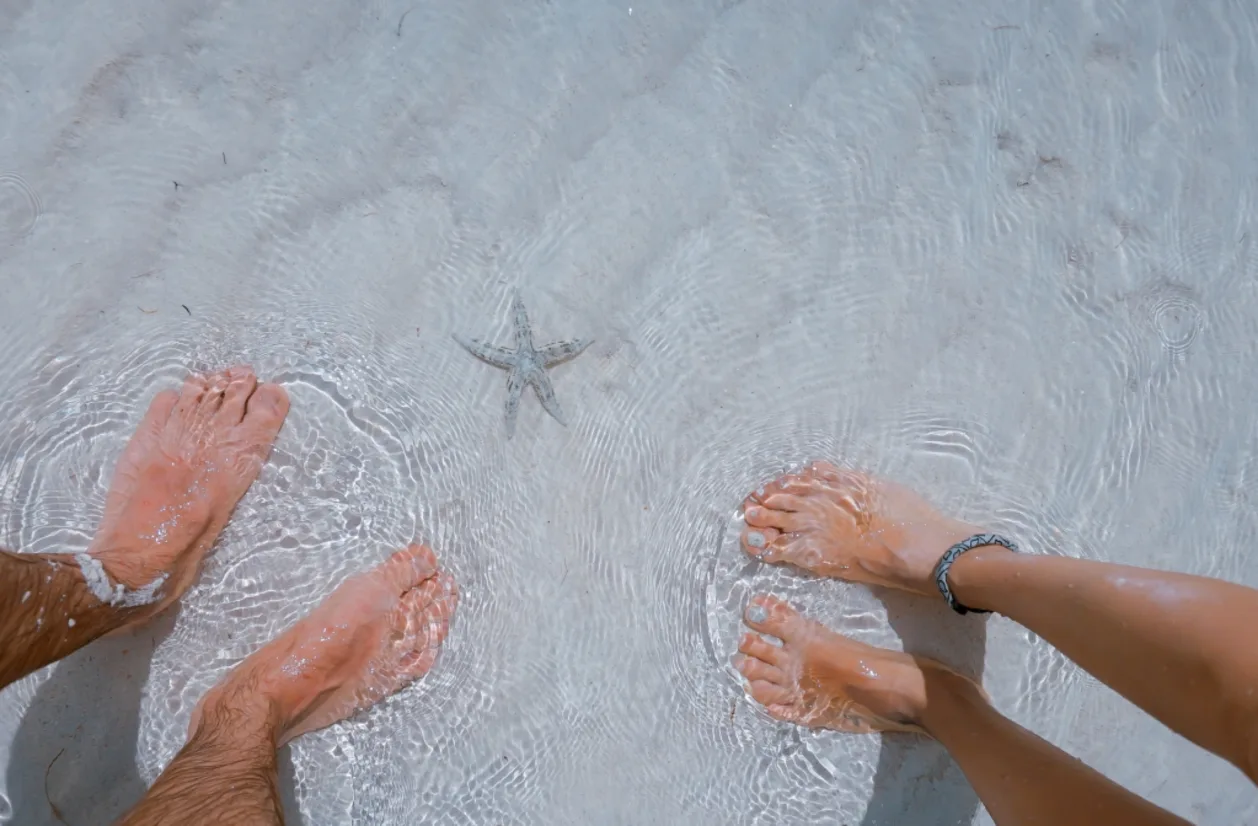 Couple grounding feet into ocean sand